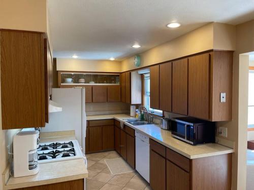 Una cocina con gabinetes de madera y un refrigerador blanco. en Hidden Gem - Modern Cozy home, en Grand Rapids