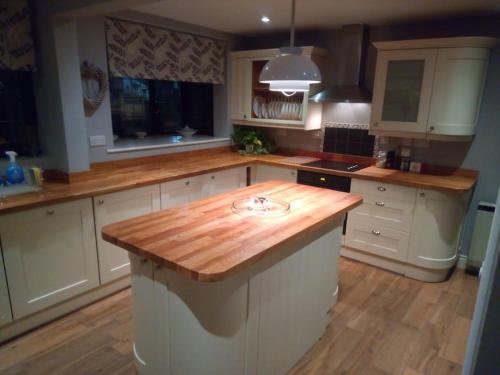 a large kitchen with a wooden counter top in it at The Retreat, a Luxury Riverside Cottage & garden in Southampton