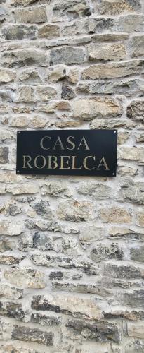a sign on the side of a brick wall at Casa Robelca in Biescas