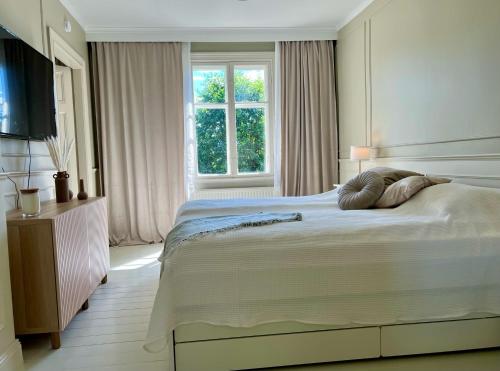 Un dormitorio con una cama grande y una ventana en Historic apartment near the city by the water, en Solna