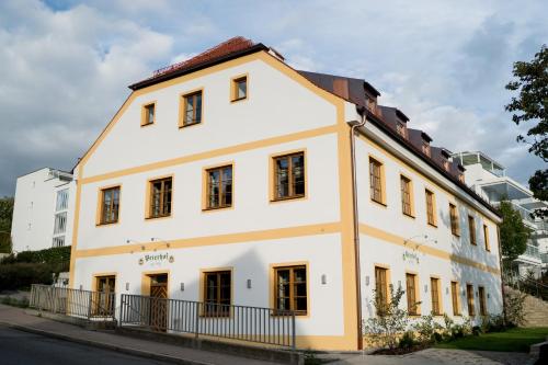 a white building with windows on a street at Bob W Peterhof in Freising
