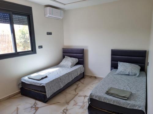 - une chambre avec 2 lits et une fenêtre dans l'établissement Villa Berkania piscine privée - 8 pers, à Berkane