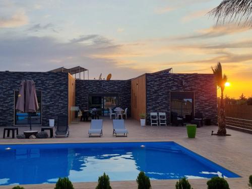 a villa with a swimming pool and a patio at Villa Berkania piscine privée - 8 pers in Berkawe