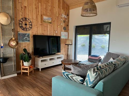 a living room with a blue couch and a television at Houses with a View#Sauna#Jaccuzi in Gozdowice