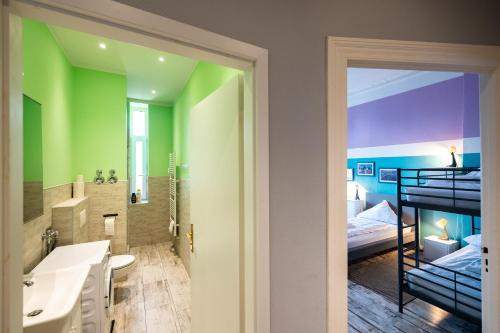 a bathroom with green walls and a bunk bed at Ferienwohnung bis 8 Personen in Berlin