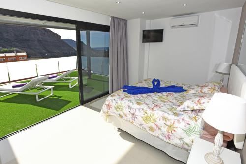 モガンにあるVilla Morro del Guincho 27のベッドルーム(ベッド1台付)、バルコニーが備わります。