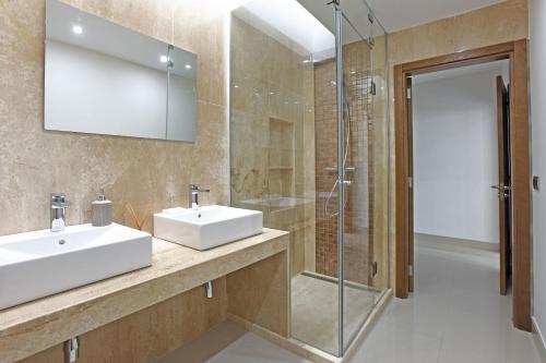 モガンにあるVilla Morro del Guincho 27のバスルーム(洗面台2台、ガラス張りのシャワー付)