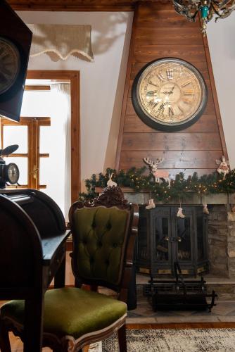 a living room with a fireplace and a clock on the wall at Dandy Villas Nymfaio - Snow Fairy - Sauna in Nimfaíon