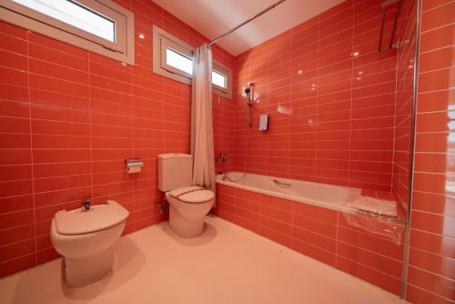 a red tiled bathroom with a toilet and a shower at Casa BlancadeNavarra in Fitero