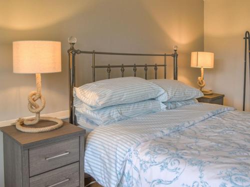 a bedroom with a bed with two lamps on a night stand at Bettys Cottage in Swafield