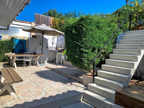 a patio with stairs and a table and an umbrella at The Loft Factory 4 Chambres Vue Garonne + Jardin in Lormont