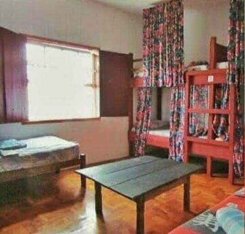 - un salon avec une table basse et une fenêtre dans l'établissement Hostel Lumiar da Serra, à Tiradentes