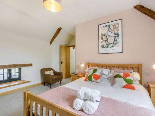 a bedroom with a bed with towels on it at Penshenkin Barn in Llanfihangel-nant-Melan