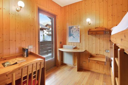 ヴァルディソットにあるMountain Chalet close to Bormioのウッドパネルの壁と窓が特徴の客室です。