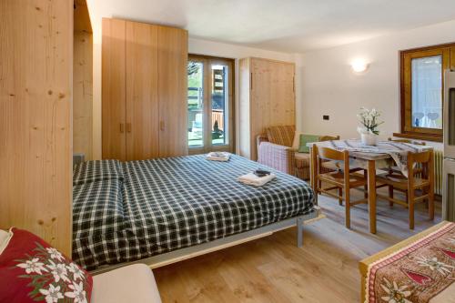 ein Schlafzimmer mit einem Bett und einem Tisch in einem Zimmer in der Unterkunft Appartamenti Vittoria Bilo in Valfurva