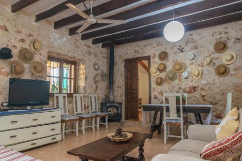 a living room with a tv and a couch and a table at Finca Son Matginet 18 in Sineu