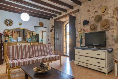 a living room with a couch and a tv on a dresser at Finca Son Matginet 18 in Sineu