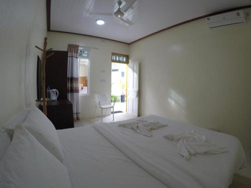 a bedroom with a white bed in a room at Konut by Thakuru in Guraidhoo