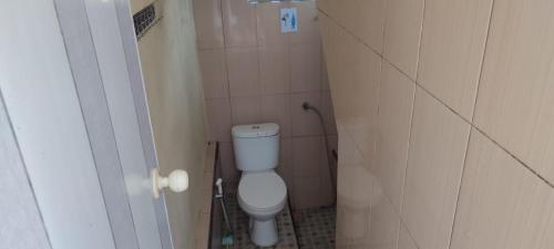 a small bathroom with a toilet in a stall at kopi ABG in Lawang