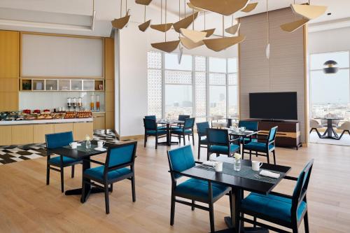 a restaurant with tables and chairs and a flat screen tv at Crowne Plaza - Jeddah Al Salam by IHG in Jeddah