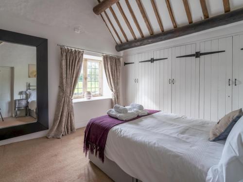 een slaapkamer met een groot bed en een grote spiegel bij Pass the Keys Delightful 4 bedroom Cotswold character cottage in Cheltenham