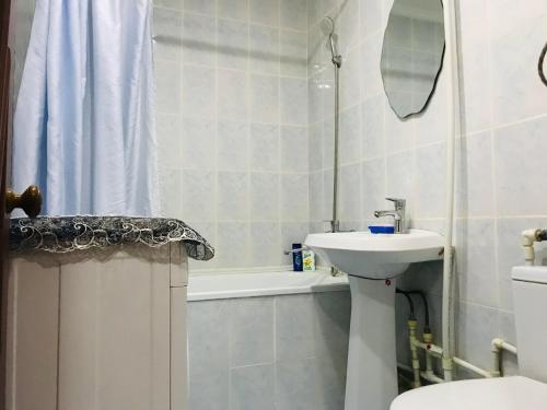 a bathroom with a sink and a toilet and a bath tub at Apartments in the city center in Karagandy