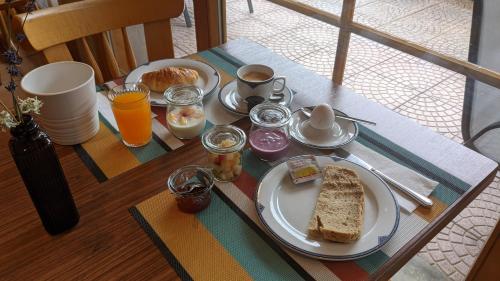 a table with a plate of food and bread on it at Hotel Beau-Séjour in Leukerbad