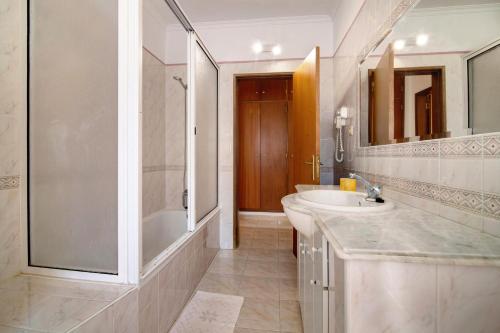 y baño blanco con lavabo y ducha. en Apartamentos Arcadia - Ana, en Guia