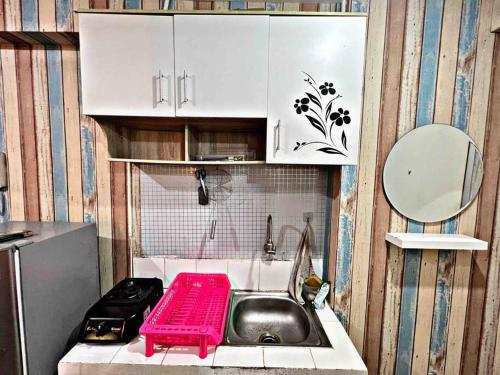 a kitchen with a sink and a pink tray at Sailor Studio 1BR + Fast Wifi+ Netflix at Greenbay Pluit in Jakarta