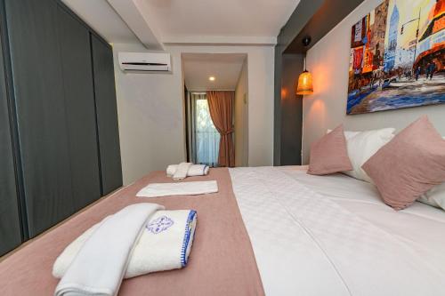 a bedroom with a large bed with two towels on it at Sarnıç - Kayaköy'de Havuzu Korunaklı in Kayakoy