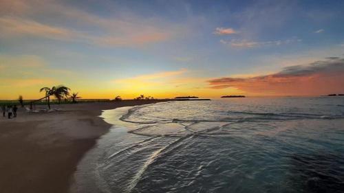 a sunset on a beach with the ocean at Konut by Thakuru in Guraidhoo