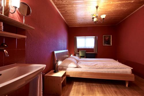 a red bedroom with a bed and a sink at Landhus Almens in Almens