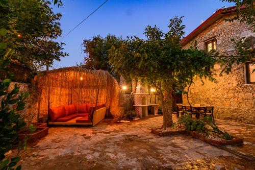 an outdoor patio with a couch and a tree at Sarnıç - Kayaköy'de Havuzu Korunaklı in Kayakoy
