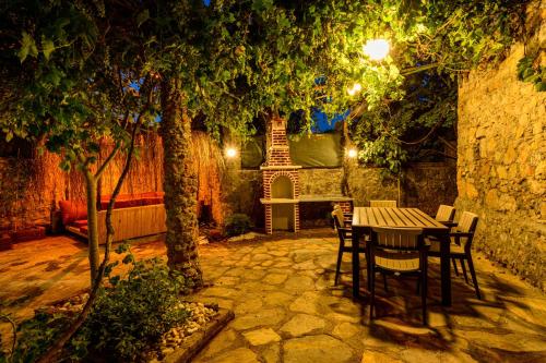 a table and chairs in a garden at night at Sarnıç - Kayaköy'de Havuzu Korunaklı in Kayakoy