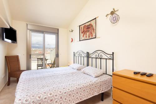 a bedroom with a bed and a dresser and a window at 121 MEDANO Perfect Stay By Sunkeyrents in El Médano