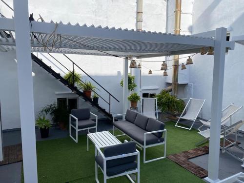 patio z krzesłami i stołem w budynku w obiekcie Gran casa señorial de 300m en centro histórico w mieście El Puerto de Santa María