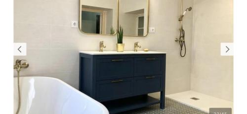 ein Badezimmer mit einem blauen Schrank und einem Spiegel in der Unterkunft Gran casa señorial de 300m en centro histórico in El Puerto de Santa María