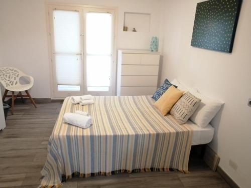 1 dormitorio con 1 cama con sábana rayada en NATURA MEDITERRANEA primera linea con piscina, en Vera