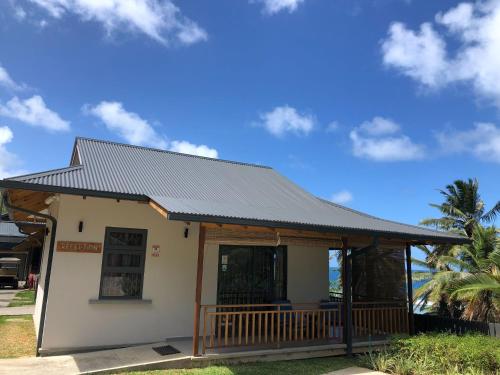 a small white building with a black roof at Paradise Chalets Yoga & Wellness in Takamaka