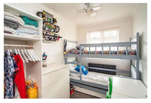 a bedroom with two bunk beds and a closet at 2 Bed - walking distance to Harry Potter Studio in Leavesden Green