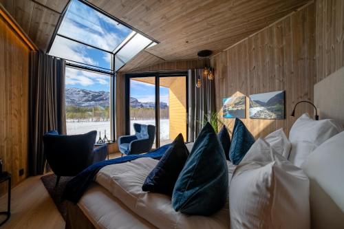 a bedroom with a bed and a large window at Sorrisniva Arctic Wilderness Lodge in Alta