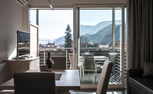 a living room with a table and a view of a balcony at Haus Wiesenstein in Lana
