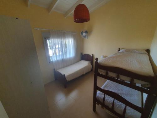 Un dormitorio con dos literas y una ventana. en Encanto Las Dunas, en Monte Hermoso