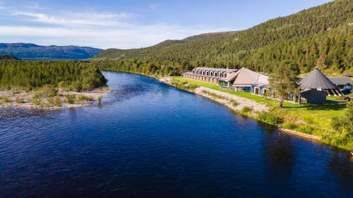 an aerial view of a river with buildings and trees at Sorrisniva Arctic Wilderness Lodge in Alta
