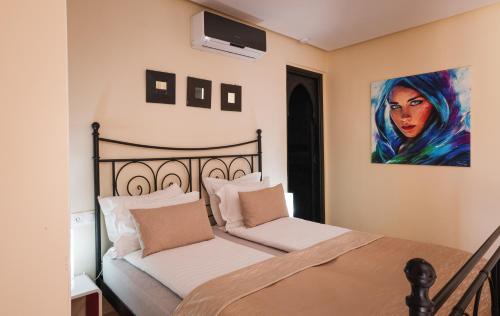 a bedroom with two beds and a painting on the wall at Tiguemine Sarah in Marrakech