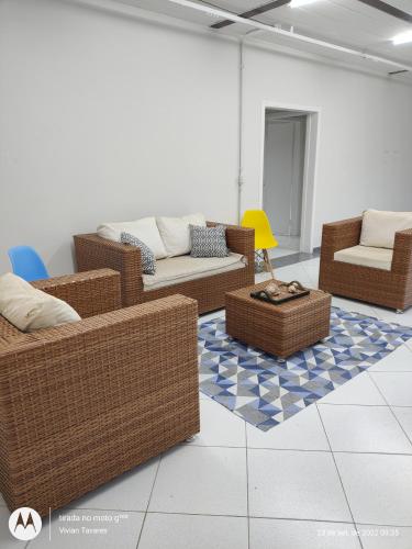 a living room with wicker chairs and couches at FRANCIS HOTEL MAR in Caraguatatuba