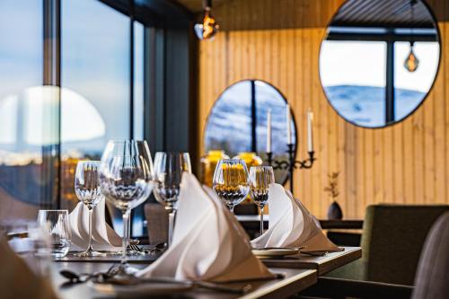 a table in a restaurant with wine glasses on it at Sorrisniva Arctic Wilderness Lodge in Alta