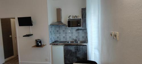 a small kitchen with a sink and a microwave at Guest Home location in Néris-les-Bains