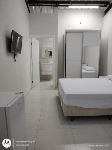 a bedroom with a bed and a tv in it at FRANCIS HOTEL MAR in Caraguatatuba
