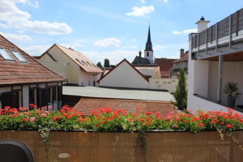 vistas a una ciudad con flores rojas en una valla en Auszeit im Rheingau, en Eltville am Rhein